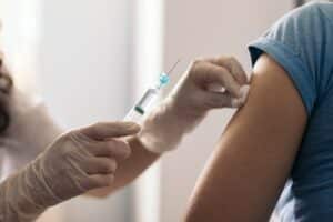 Vaccination par une infirmière en gants.